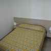 Letto matrimoniale con copriletto a righe gialle.
