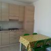 Cucina con tavolo e sedie verdi.