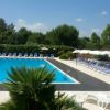 Piscina circondata da lettini e ombrelloni.