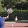 Partita di tennis tra due persone su campo all'aperto.
