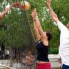 Partita di pallavolo con tre persone che saltano attorno alla rete.