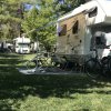 Camper parcheggiato con biciclette e sedie.