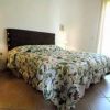 Camera con letto matrimoniale, lampade e copriletto floreale.