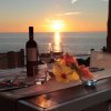 Tavolo con cena romantica al tramonto, vista mare.