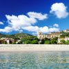 Spiaggia con edificio storico sullo sfondo.