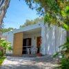 Bungalow bianco in giardino verde.