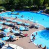 Ampia piscina con lettini e ombrelloni.