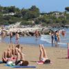 Persone in spiaggia fanno esercizi sul bagnasciuga.