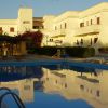 Complesso residenziale con piscina e sdraio.