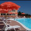Piscina con lettini e ombrelloni arancioni.