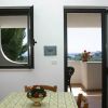 Interno con tavolo fiorito e vista su balcone.