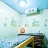 Stanza massaggi con lettino e decorazioni tropicali.