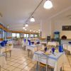 Una sala da pranzo con tavoli apparecchiati con tovaglie bianche e decorazioni blu.