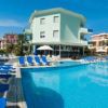 Piscina all'aperto con lettini blu e ombrelloni vicino a edifici residenziali.