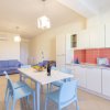 Cucina e sala con tavolo bianco e sedie blu.