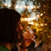 Persona beve vino con luci sullo sfondo.