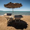 Due lettini con ombrellone su una spiaggia sabbiosa.