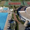 Vista dall'alto di piscina e campi da tennis.