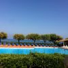 Piscina scoperta con lettini e vista mare.