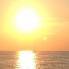 Tramonto sul mare con una barca a vela.