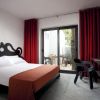 Camera con letto matrimoniale, copriletto rosso, tendaggi rossi, e porta finestra con vista cortile.