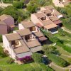 Vista aerea di villette con tetti in tegole e giardini.