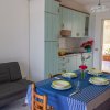 Cucina con tavolo apparecchiato e divano grigio.