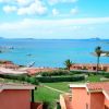 Tetti di case con vista sul mare e cielo azzurro.
