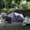 Tenda grigia con motocicletta e scooter parcheggiati.