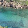 Acqua cristallina con sfumature turchesi circondata da rocce.