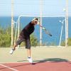 Ragazzo gioca a tennis vicino al mare.
