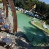 Piscina all'aperto con sedie e tavoli su un pontile.