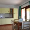 Cucina con mobili gialli e tavolo da pranzo in legno.