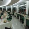 Sala da pranzo elegante con tavoli quadrati apparecchiati e luci soffuse.