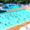 Piscina con persone che partecipano ad attività acquatiche, presenti scivoli.