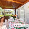 Veranda coperta di una casa mobile con tavolo apparecchiato colorato e fiori.