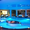 Piscina illuminata di blu in un ambiente interno elegante con lettini.