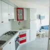 Cucina moderna bianca con dettagli rossi.