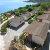 Vista aerea di bungalow sulla costa con vegetazione.