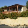 Chalet con fiori arancioni e veranda in legno.