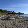 Spiaggia con lettini e ombrelloni di paglia.