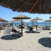 Spiaggia con ombrelloni di paglia e lettini.