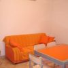Soggiorno con divano e tavolo arancioni, aria condizionata.