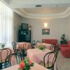 Sala da pranzo con tavoli decorati con fiori, pareti chiare e sedie nere.