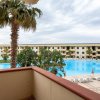 Balcone con vista su piscina e palme.