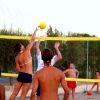 Persone giocano a beach volley sulla sabbia.