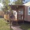 Una casa mobile con veranda e scale in legno su un prato verde.