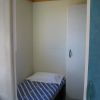 Letto singolo con lenzuola a righe blu e bianche vicino a un armadio.