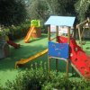 Parco giochi con scivoli e altalene su prato verde.