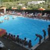 Piscina estiva affollata di persone.